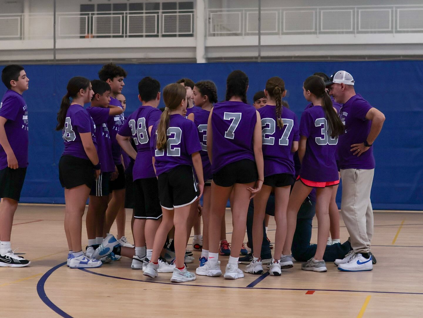 Girls’ basketball team in purple jerseys in the gym