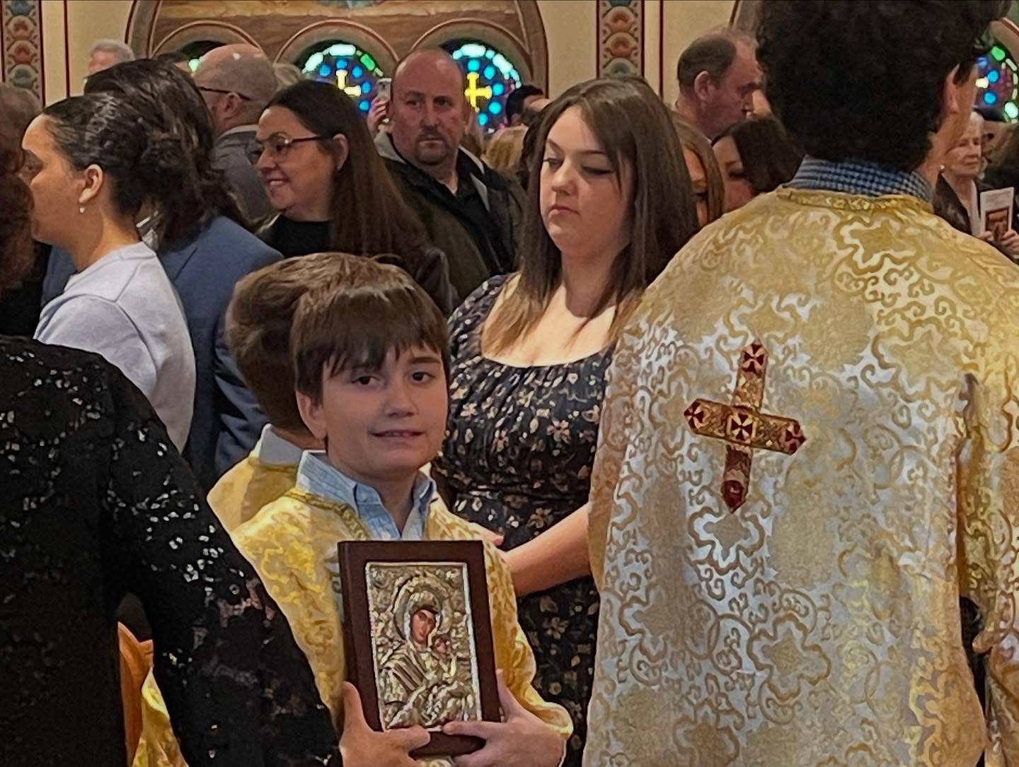Children holding icons with a priest after the Divine Liturgy